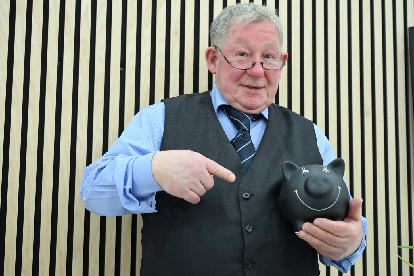 Werner Schnitzlein mit einem Sparschwein als Symbol für den Vermögensaufbau